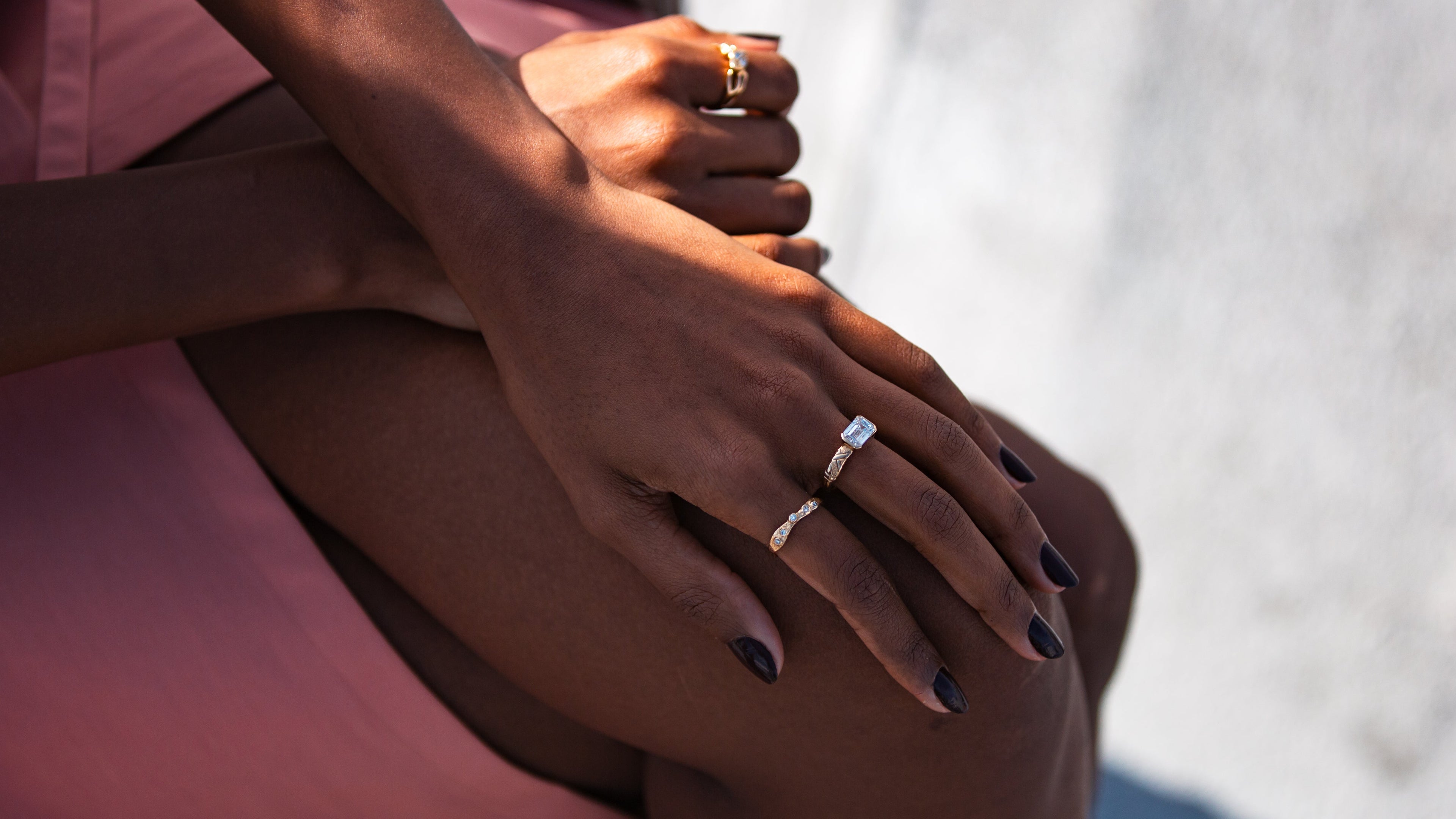 Close-up of a person wearing two rings on their fingers against a white background